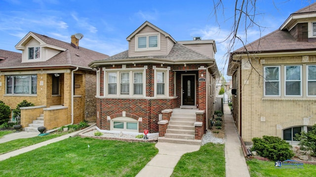 bungalow featuring brick siding, a front lawn, and roof with shingles