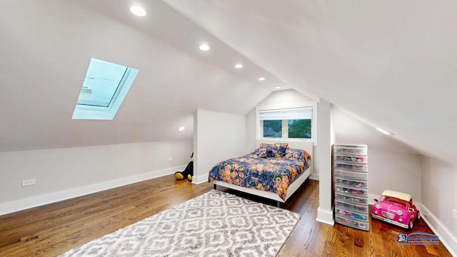 bedroom featuring vaulted ceiling with skylight, baseboards, recessed lighting, and wood finished floors