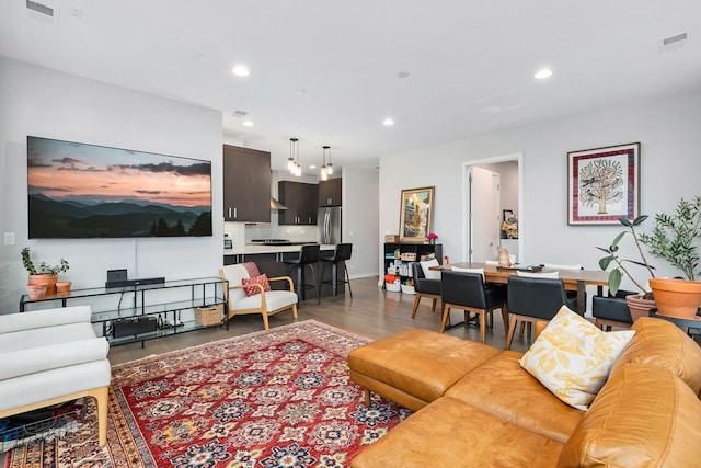 living area with recessed lighting, wood finished floors, and visible vents