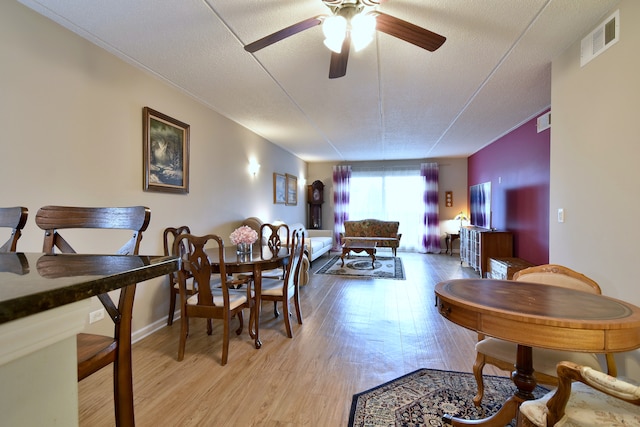 dining space featuring visible vents, light wood-style flooring, and ceiling fan