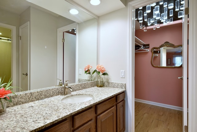 bathroom featuring vanity, baseboards, and wood finished floors