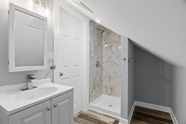 full bathroom with vanity, a stall shower, and wood finished floors