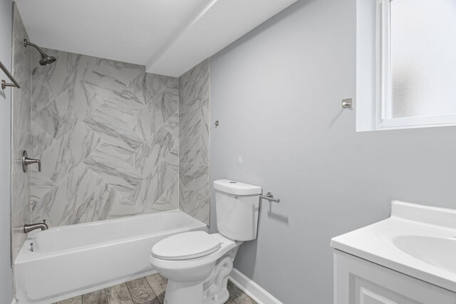 bathroom featuring vanity, wood finished floors, toilet, baseboards, and shower / tub combination