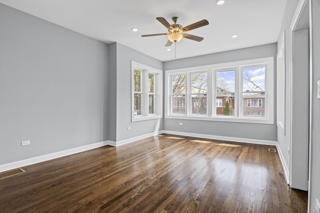 unfurnished room featuring a ceiling fan, visible vents, baseboards, recessed lighting, and dark wood-type flooring