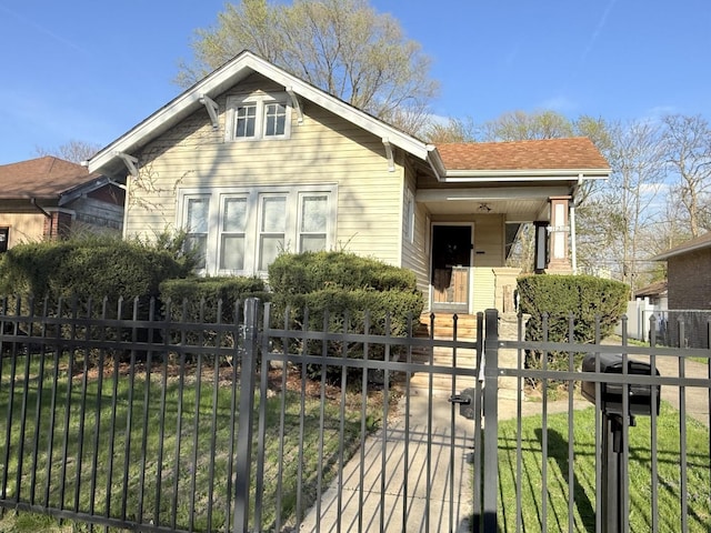 bungalow with a gate, a fenced front yard, a porch, and a front lawn