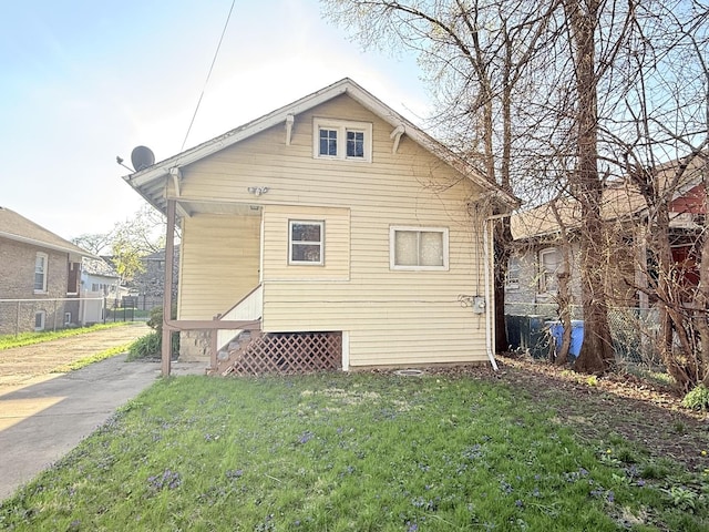 back of house with a lawn, fence, and entry steps