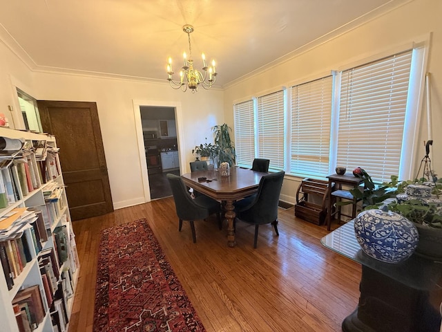 dining area with crown molding, baseboards, hardwood / wood-style floors, and a chandelier