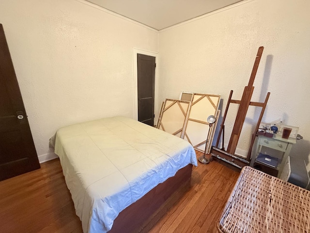 bedroom featuring a textured wall and wood finished floors