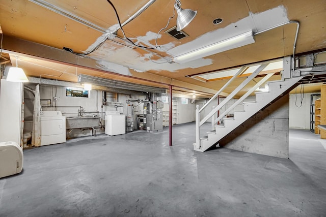 unfinished basement with washer / clothes dryer, a sink, and stairway