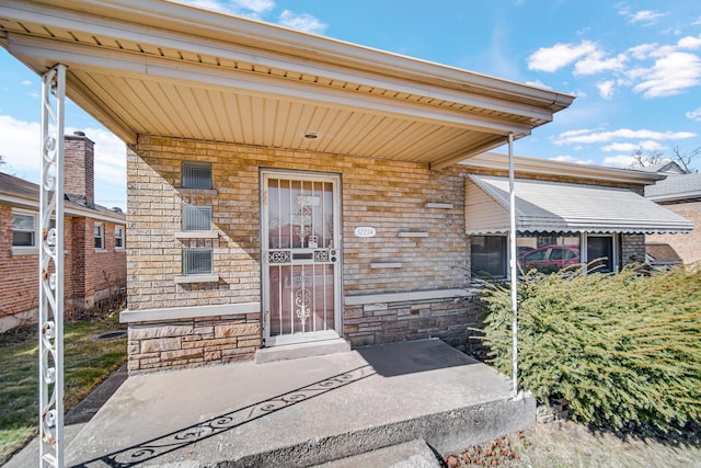 view of exterior entry featuring covered porch