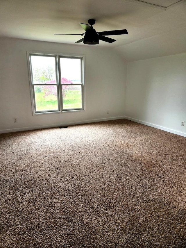 carpeted spare room with baseboards, ceiling fan, and lofted ceiling