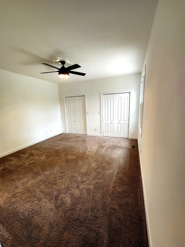 spare room with baseboards, a ceiling fan, carpet, and visible vents