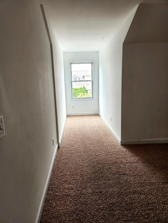 corridor with carpet floors and baseboards