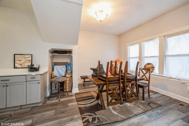 dining area featuring visible vents, baseboards, and dark wood-style floors