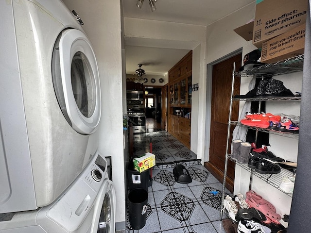 washroom featuring stacked washing maching and dryer, tile patterned flooring, and laundry area