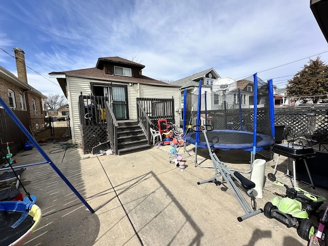 back of property with fence and a trampoline
