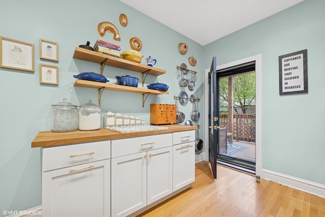 dining room featuring light wood-style floors, baseboards, ornamental molding, and a chandelier