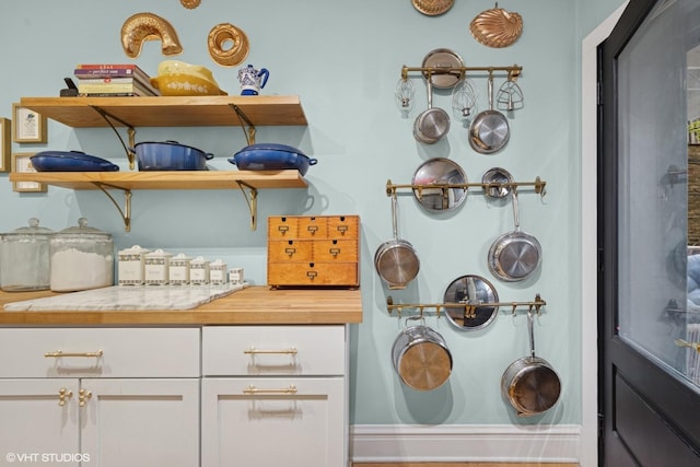 kitchen featuring open shelves, light wood-type flooring, white cabinetry, wood counters, and stainless steel appliances