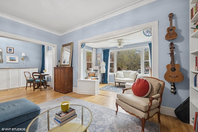 living area featuring crown molding, baseboards, built in shelves, and light wood-style flooring