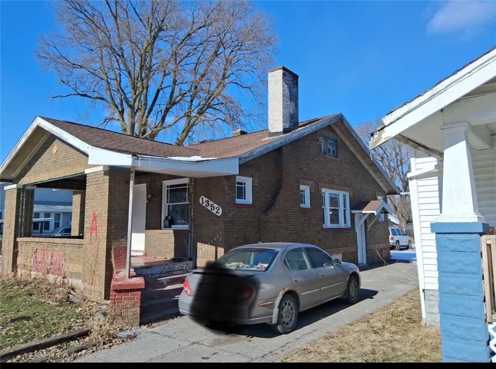 1352 E Locust St, Decatur, IL 62521 - view of front of home featuring covered porch, brick siding, and a chimney