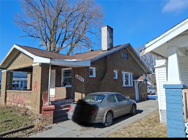 1352 E Locust St, Decatur, IL 62521 - view of front of home featuring covered porch, brick siding, and a chimney