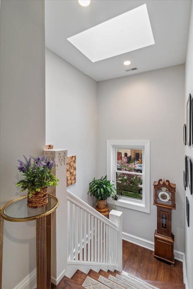 4336 N Troy St, Chicago, IL 60618 - stairway with visible vents, baseboards, wood finished floors, and a skylight