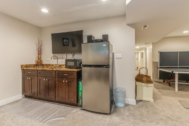 4336 N Troy St, Chicago, IL 60618 - kitchen with black microwave, a sink, stone countertops, freestanding refrigerator, and baseboards
