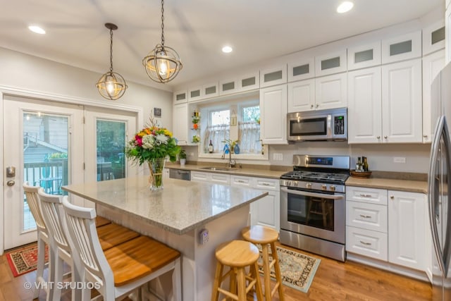 4336 N Troy St, Chicago, IL 60618 - kitchen with a sink, white cabinets, a kitchen bar, and stainless steel appliances