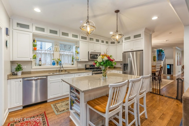4336 N Troy St, Chicago, IL 60618 - kitchen featuring light stone countertops, a kitchen breakfast bar, white cabinetry, a sink, and stainless steel appliances