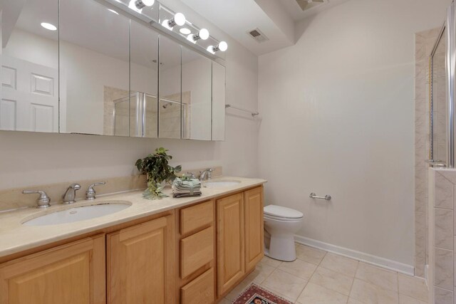 bathroom featuring a sink, toilet, tile patterned floors, visible vents, and a stall shower