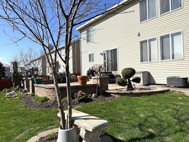back of house with a lawn, central AC unit, and a patio