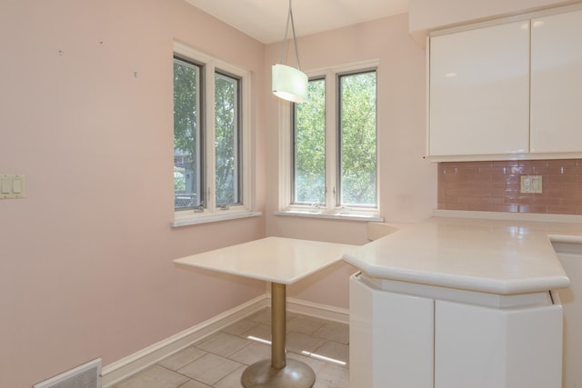 2001 Woodland Ave, Park Ridge, IL 60068 - unfurnished dining area featuring light tile patterned floors, baseboards, and plenty of natural light
