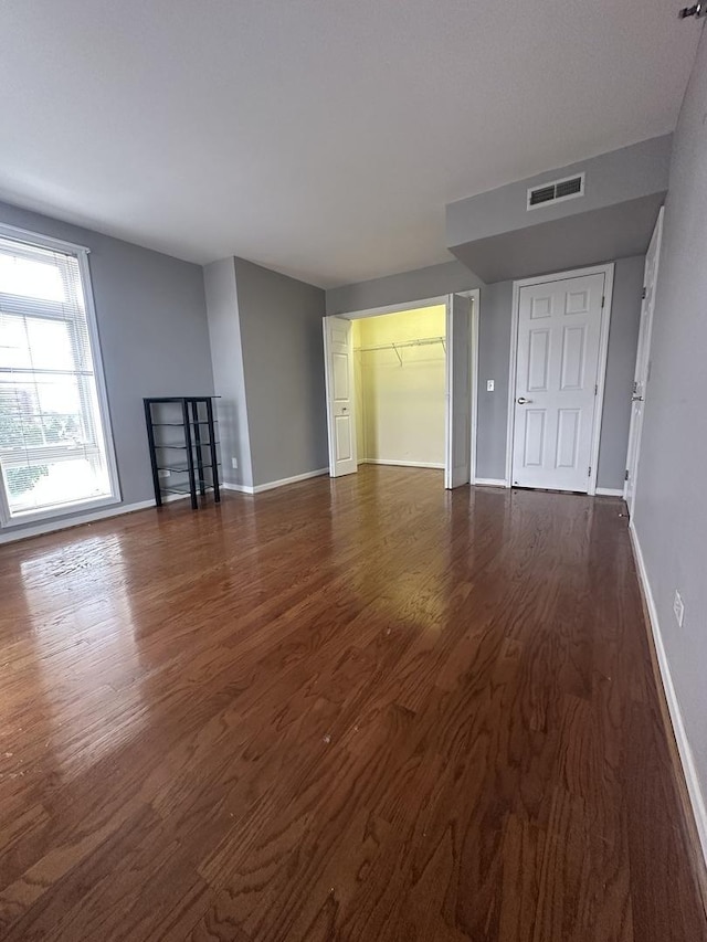 7091 W Touhy Ave Unit 509, Niles, IL 60714 - unfurnished living room featuring dark wood-style flooring and baseboards