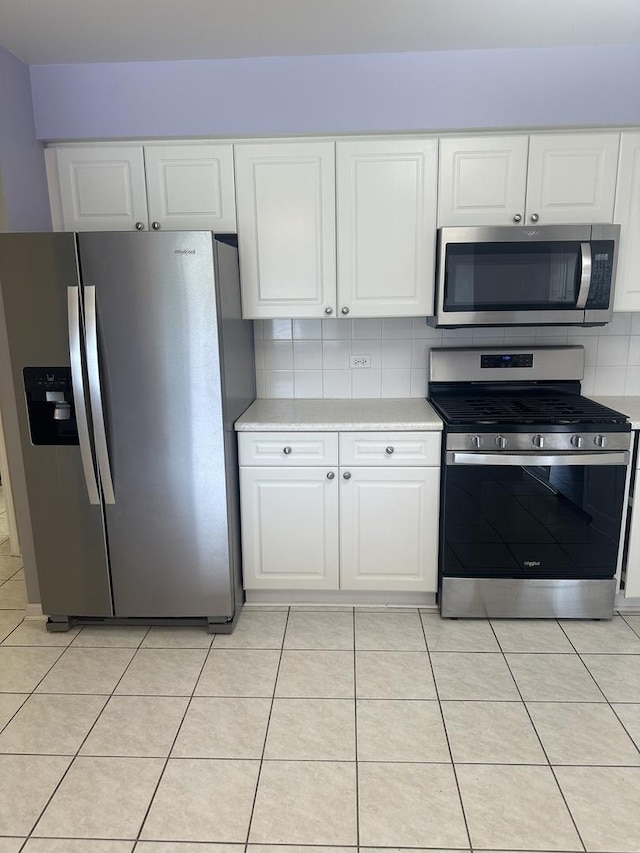 7091 W Touhy Ave Unit 509, Niles, IL 60714 - kitchen featuring stainless steel appliances, light countertops, decorative backsplash, white cabinets, and light tile patterned floors