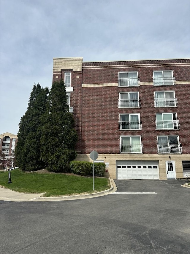 7091 W Touhy Ave Unit 509, Niles, IL 60714 - view of building exterior featuring an attached garage and asphalt driveway