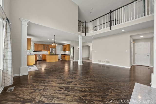 2716 Whitchurch Ct, Naperville, IL 60564 - unfurnished living room featuring ornate columns, a high ceiling, visible vents, and dark wood-type flooring