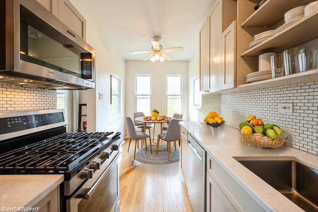 4240 N Clarendon Ave Unit 301S, Chicago, IL 60613 - kitchen featuring stainless steel appliances, backsplash, light wood-type flooring, and plenty of natural light
