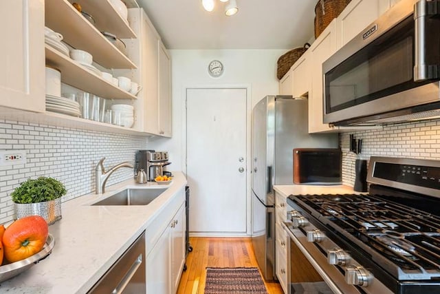 4240 N Clarendon Ave Unit 301S, Chicago, IL 60613 - kitchen with stainless steel appliances, a sink, light wood-style flooring, and backsplash