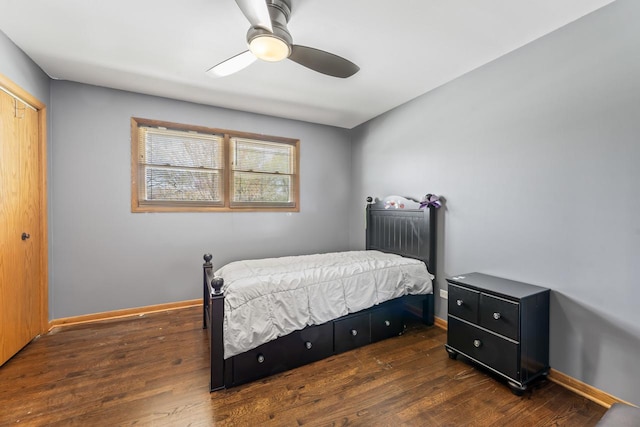 bedroom with baseboards, ceiling fan, wood finished floors, and a closet