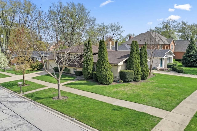 view of front of property with a chimney, roof with shingles, a residential view, a front lawn, and stucco siding