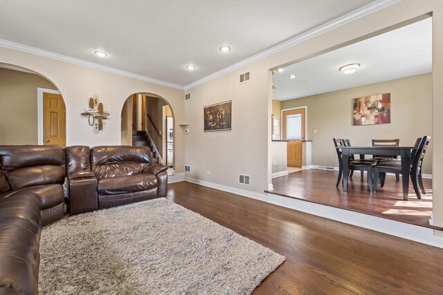 living room with ornamental molding, baseboards, recessed lighting, arched walkways, and dark wood finished floors