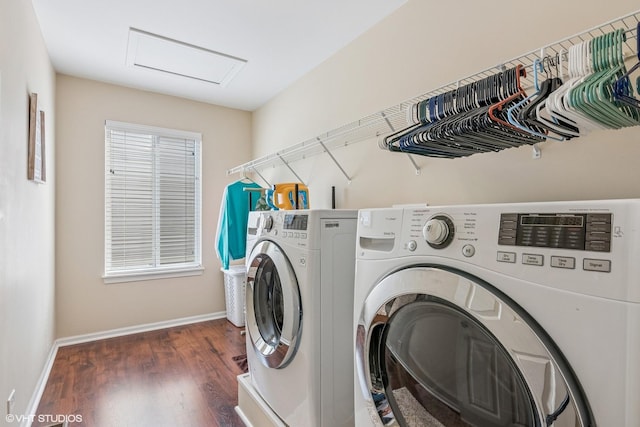 laundry area featuring washing machine and clothes dryer, attic access, wood finished floors, and baseboards