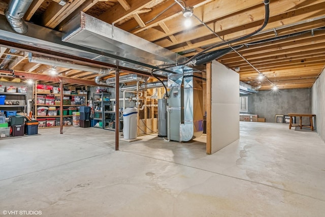 unfinished below grade area featuring water heater, heating unit, and a water softener system
