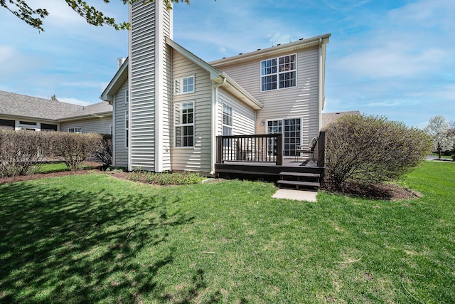 back of property featuring a yard, a chimney, and a wooden deck