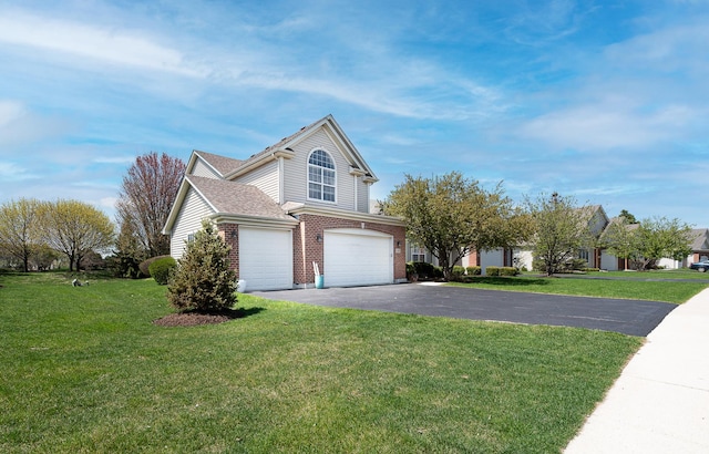 view of front of house featuring brick siding, an attached garage, a front yard, and aphalt driveway