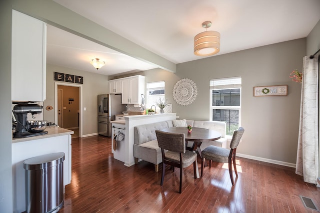 dining space with baseboards, visible vents, and dark wood finished floors