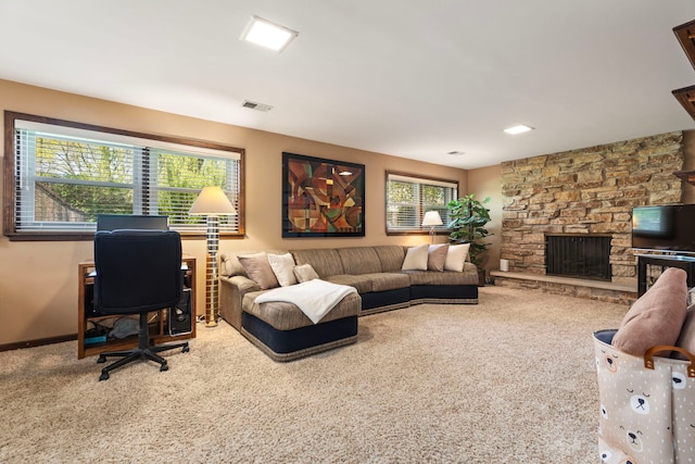 living room featuring carpet floors, plenty of natural light, a fireplace, and a desk