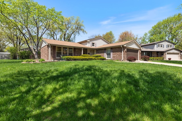 view of front facade with brick siding, a garage, a front yard, and concrete driveway