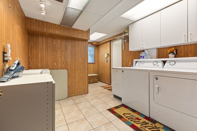 laundry room with cabinet space, independent washer and dryer, light tile patterned floors, and wooden walls