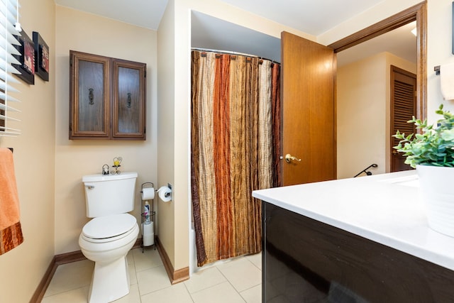 bathroom featuring toilet, vanity, baseboards, and tile patterned floors